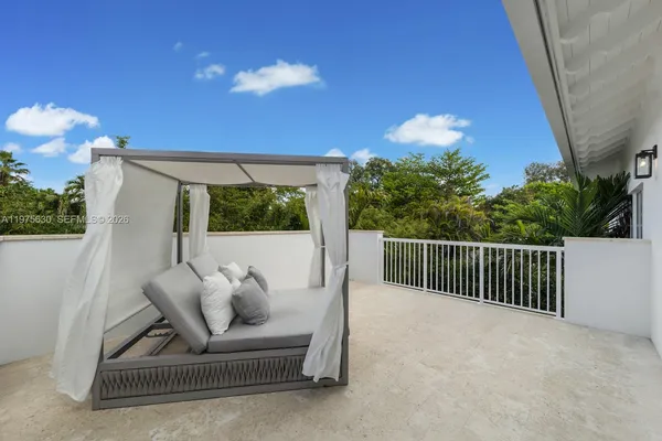 a balcony with furniture and a potted plant
