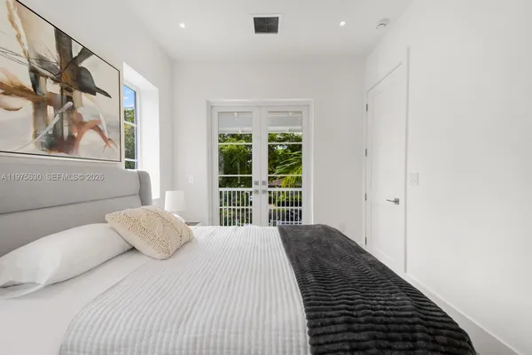 a bedroom with a large bed and a large window