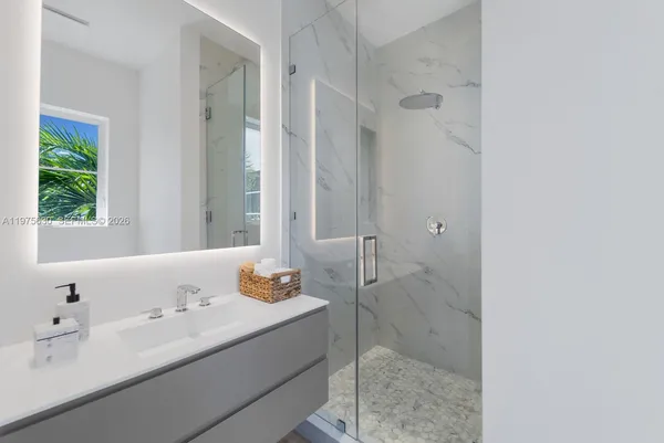 a bathroom with a bathtub shower sink vanity and toilet