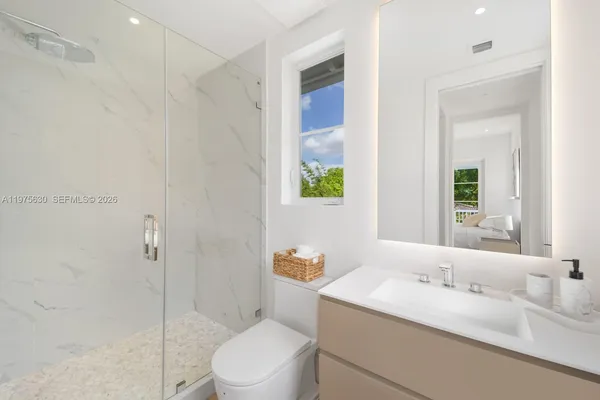 a bathroom with a granite countertop sink a toilet and shower
