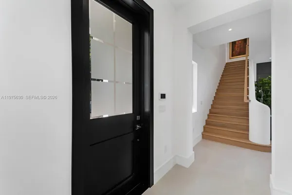 a view of a hallway with wooden floor and staircase