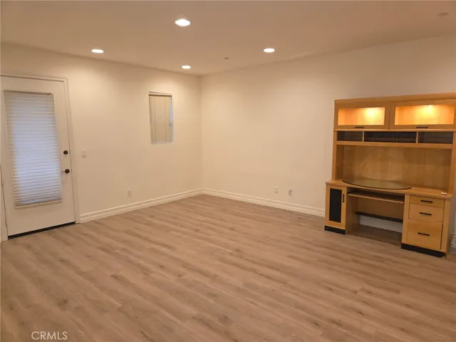 an empty room with wooden floor and bathroom