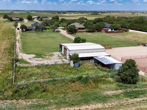an aerial view of a house with a yard and lake view