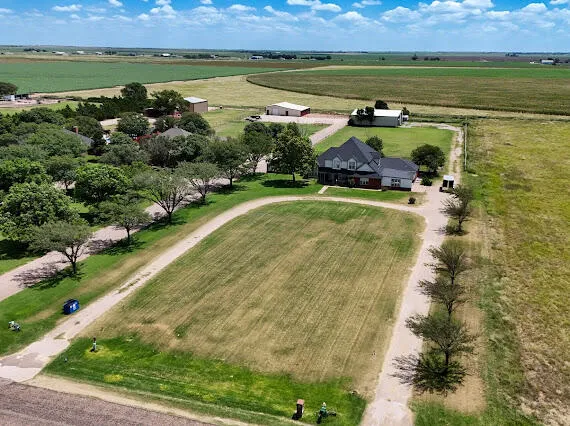 an aerial view of a house with a garden and lake view