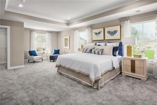 a spacious bedroom with a bed and large windows