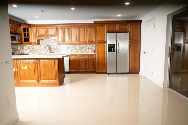 a view of a kitchen with a sink and a refrigerator