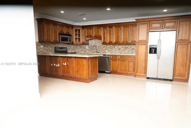 a kitchen with stainless steel appliances granite countertop a sink and a refrigerator