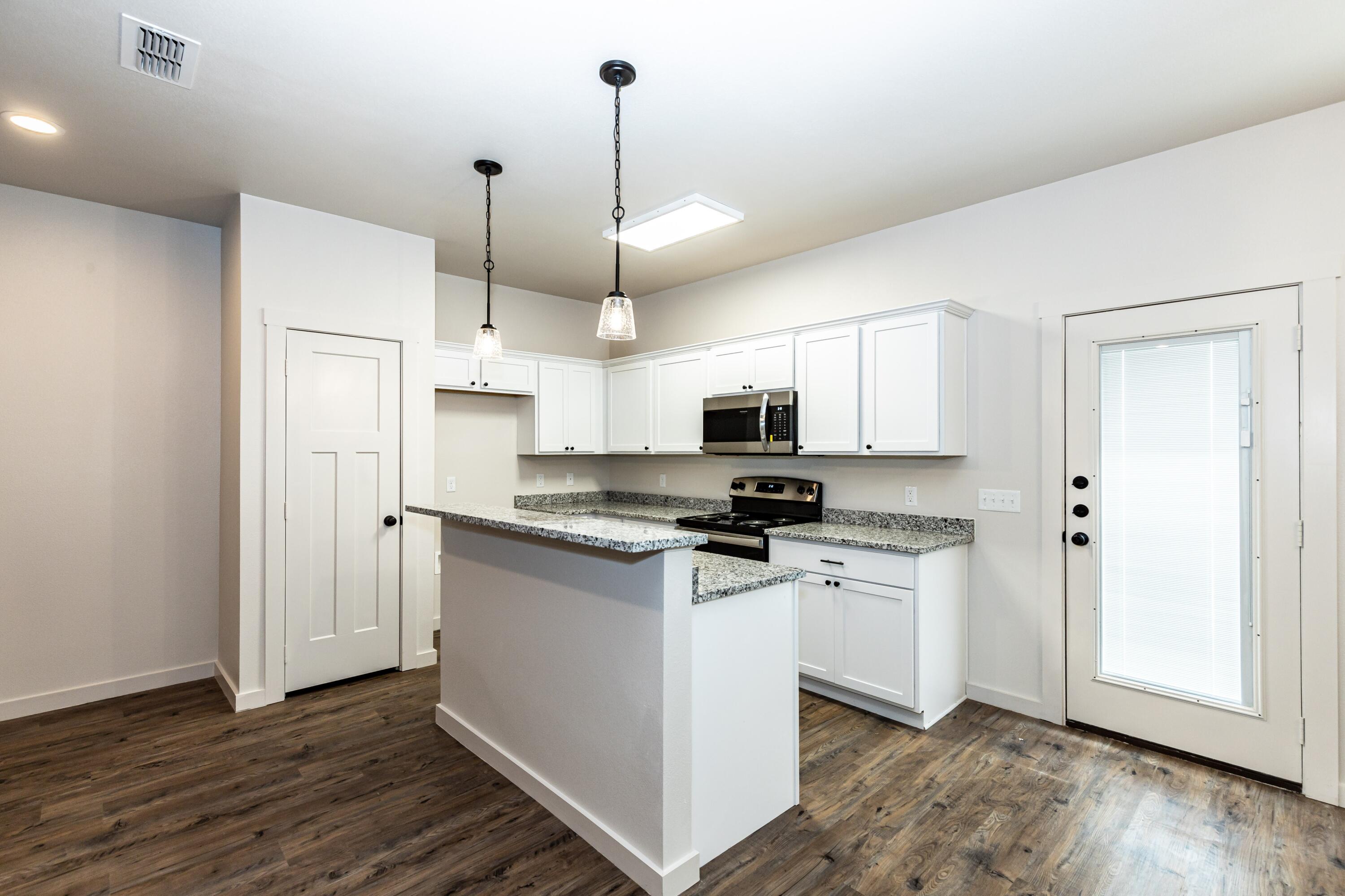 2529 138th Street Lubbock, TX 79423 - Photo 7 of 24 a kitchen with stainless steel appliances a stove a refrigerator and white cabinets