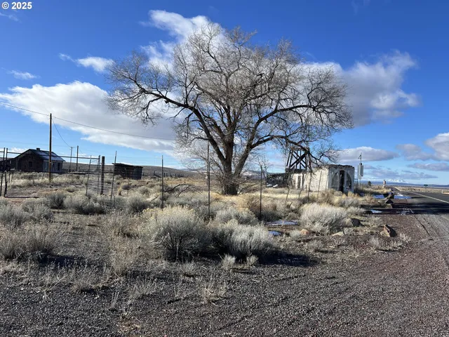 a view of a yard with wooden fence