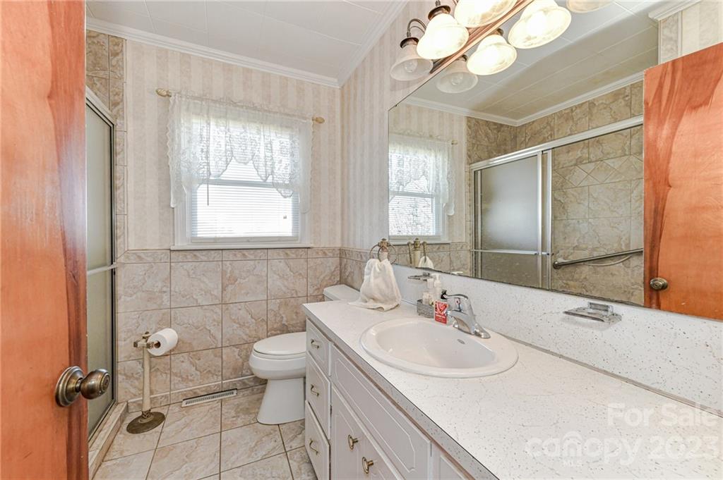 10008 Landsford Road Monroe, NC 28112 - Photo 17 of 32 a bathroom with a sink a toilet a mirror and shower