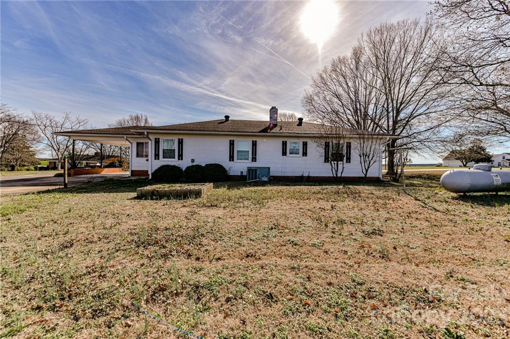 10008 Landsford Road Monroe, NC 28112 - Photo 28 of 32 a front view of a house with a garden and trees