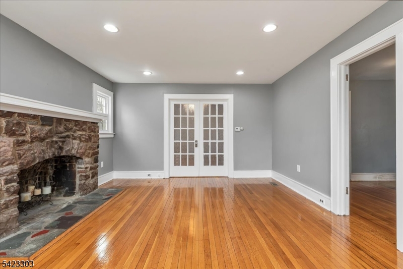 a view of empty room with wooden floor and fireplace