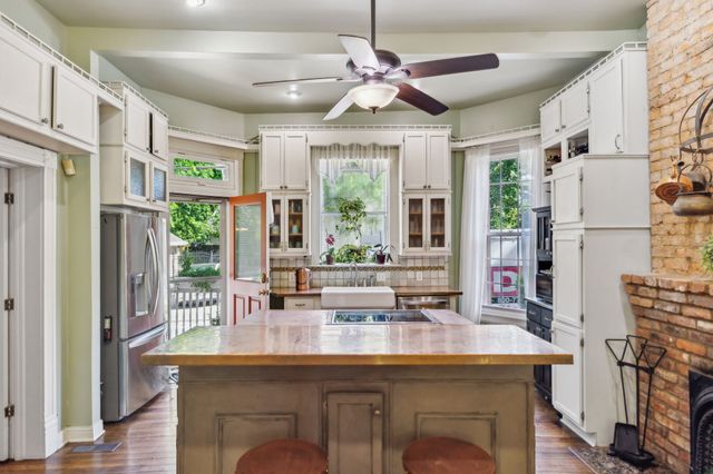 a view of a patio with table and chairs potted plants and large tree