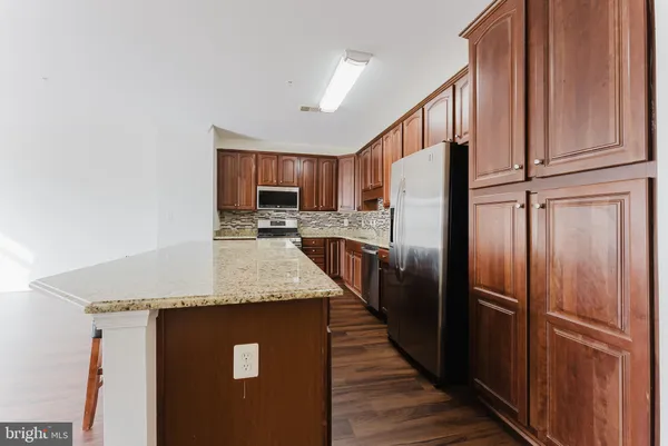 a kitchen with stainless steel appliances granite countertop a refrigerator a sink and a stove