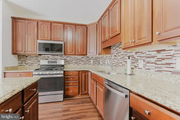 a kitchen with stainless steel appliances granite countertop a sink stove and microwave