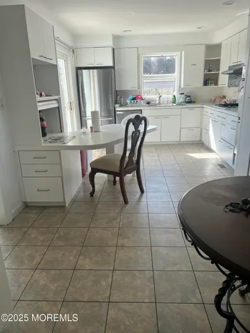 a kitchen with stainless steel appliances a stove a sink a table and chairs