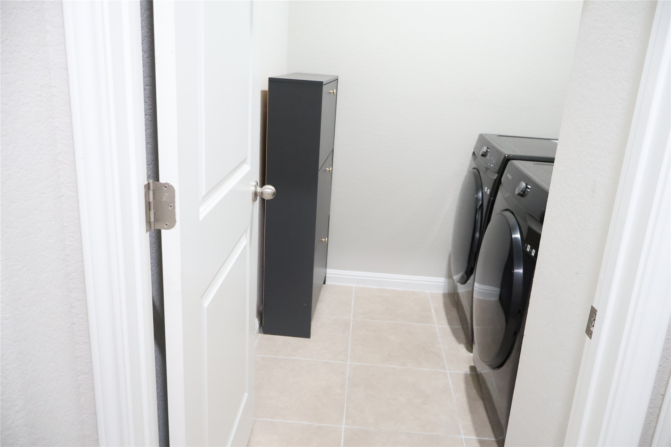11500 Maple Leaf Way Manor, TX 78653 - Photo 10 of 29 Laundry area featuring washer and clothes dryer and light tile patterned floors