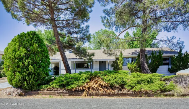 a front view of a house with a yard and potted plants