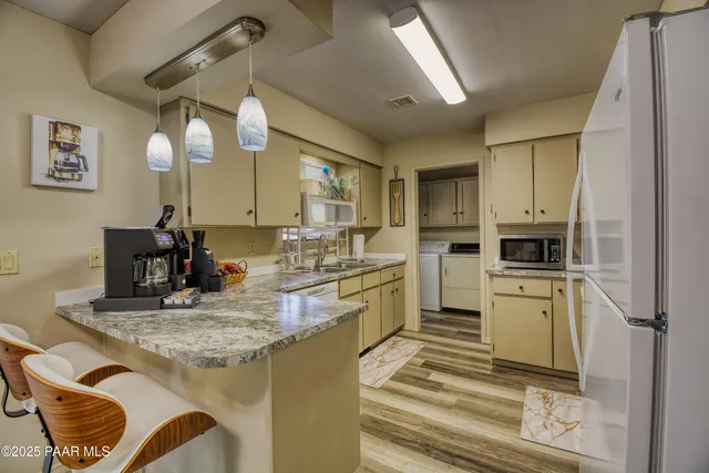 a kitchen with kitchen island granite countertop a sink cabinets and stainless steel appliances