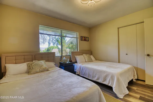 a bedroom with two beds and a large window