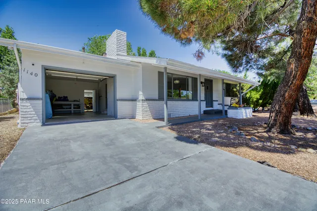 a front view of a house with a yard and potted plants