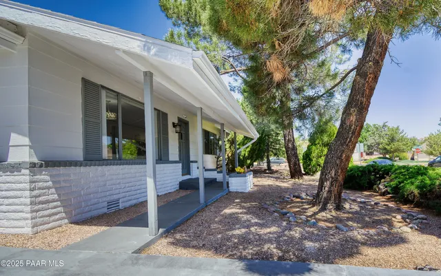 a view of a house with backyard and sitting area