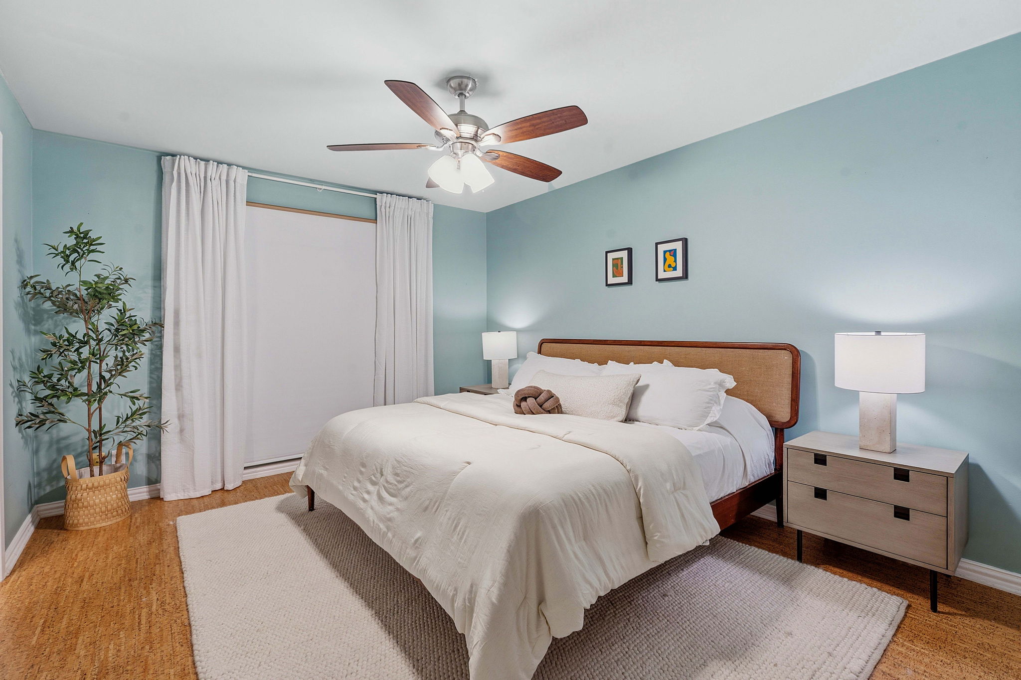 1210 Windsor Road, Unit 104 Austin, TX 78703 - Photo 16 of 29 A well-lit bedroom features hardwood flooring and a ceiling fan for comfort.