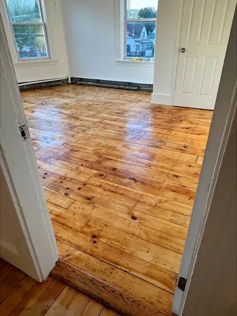 a view of an empty room and wooden floor