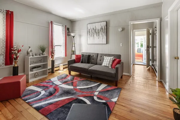 a living room with furniture and wooden floor