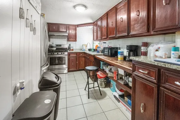 a kitchen with stainless steel appliances a stove a sink dishwasher and cabinets with wooden floor