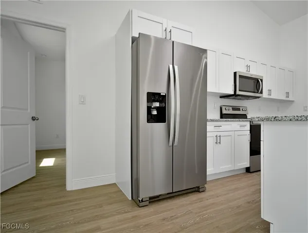 a kitchen with stainless steel appliances granite countertop a refrigerator and a stove top oven