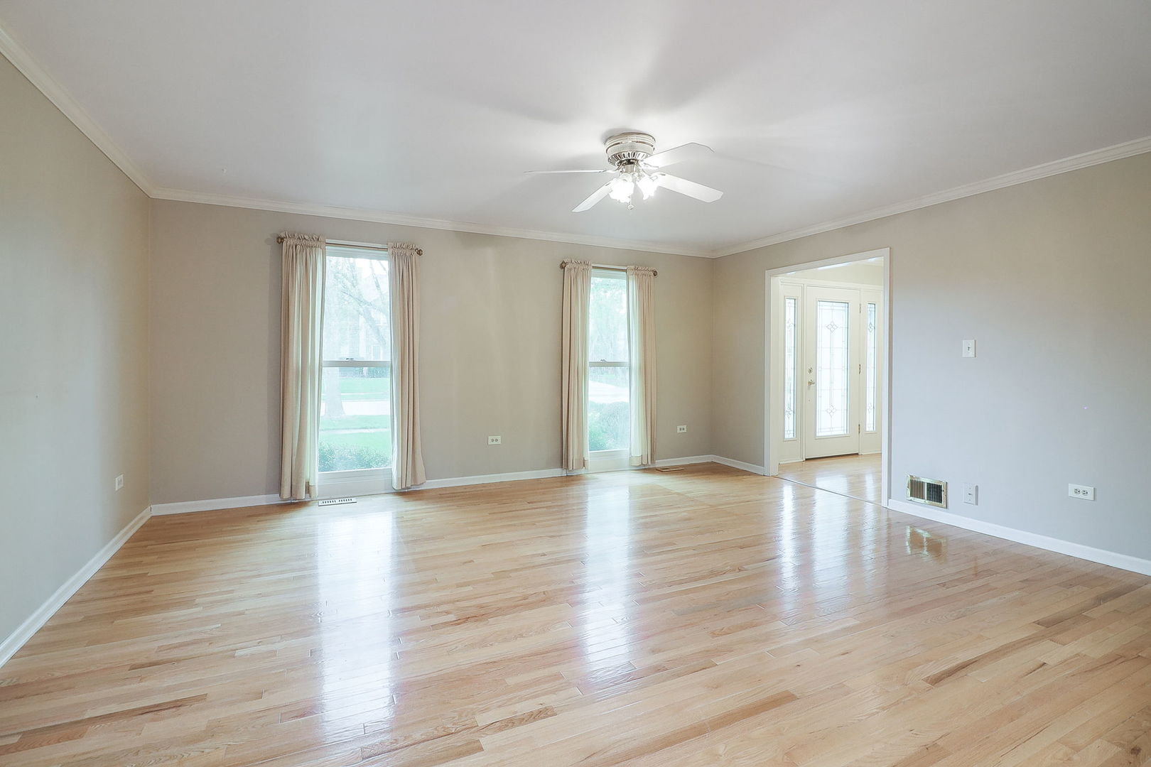 523 Cassin Road Naperville, IL 60565 - Photo 4 of 26 a view of an empty room with wooden floor and window