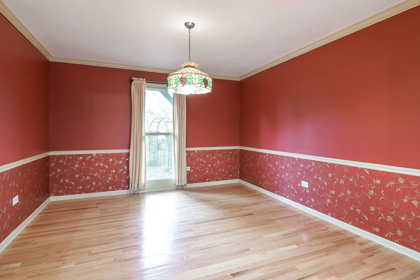 523 Cassin Road Naperville, IL 60565 - Photo 6 of 26 a view of an empty room with wooden floor and a window