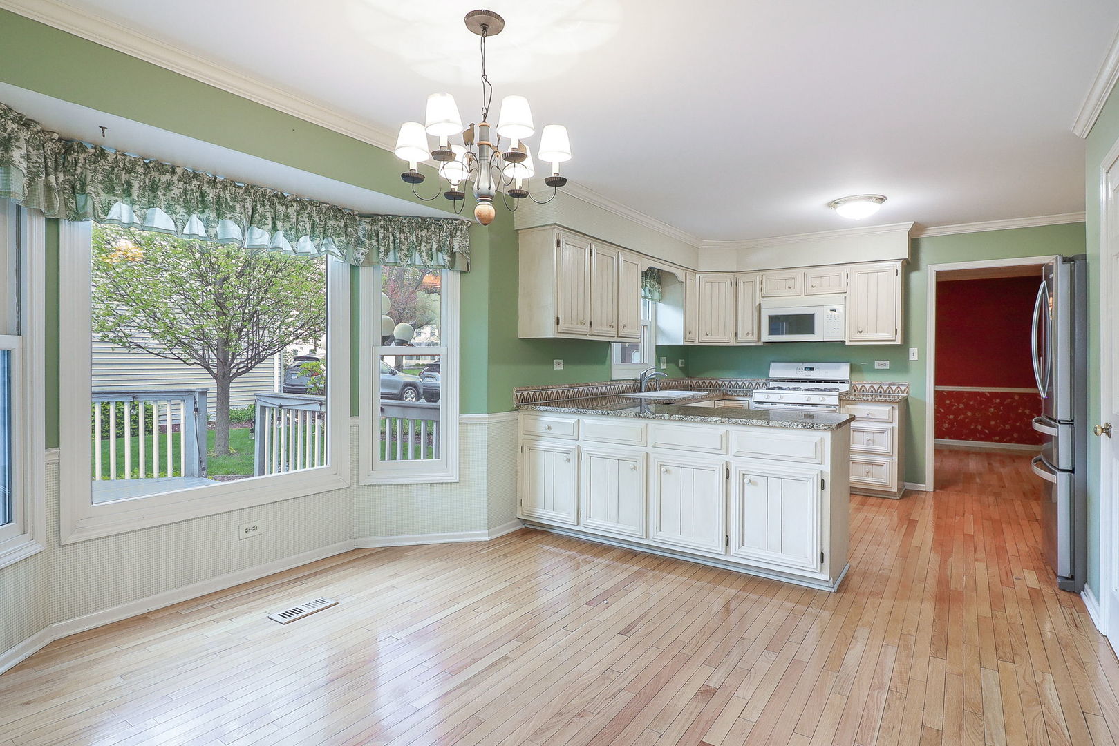 523 Cassin Road Naperville, IL 60565 - Photo 7 of 26 a kitchen with stainless steel appliances granite countertop a refrigerator a stove a sink dishwasher and white cabinets with wooden floor