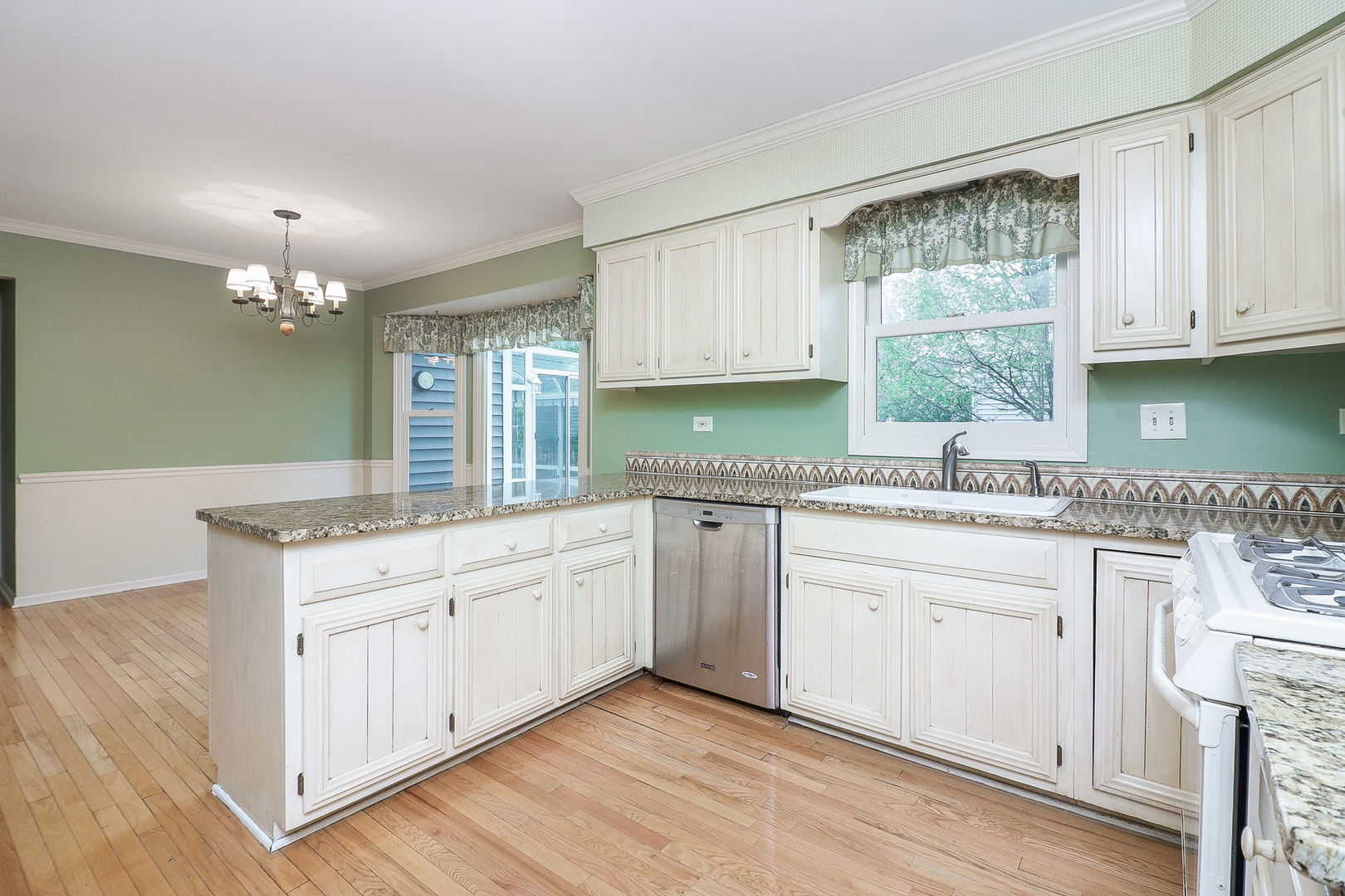 523 Cassin Road Naperville, IL 60565 - Photo 10 of 26 a kitchen with granite countertop white cabinets white appliances a sink and a large window