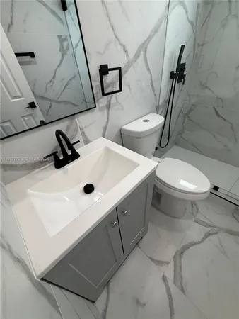 a bathroom with a sink mirror vanity and toilet