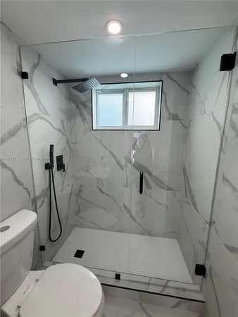 a bathroom with a toilet and a shower