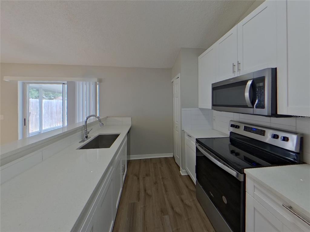 Undisclosed Address Riverview, FL 33578 - Photo 5 of 15 a kitchen with wooden cabinets and a stove top oven