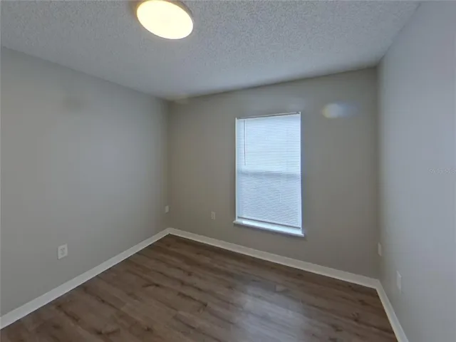 a view of an empty room with closet and a window