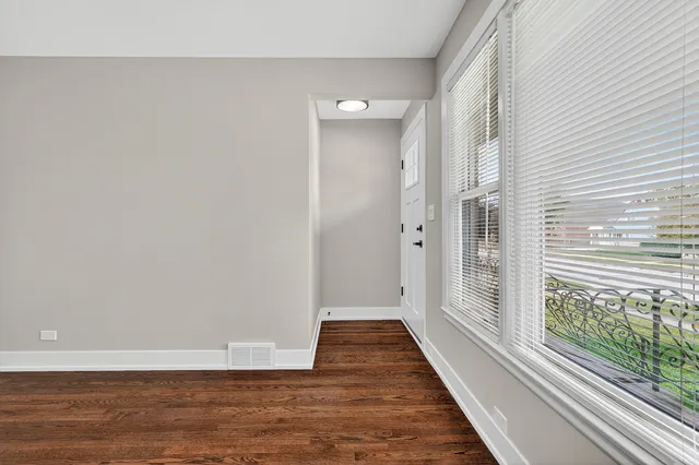 a view of a room with wooden floor and a window