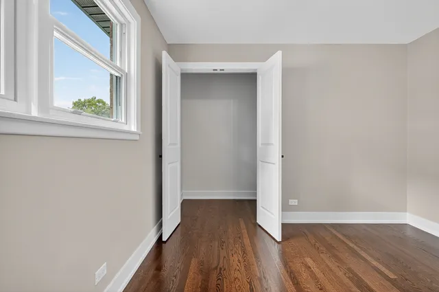 a view of a hallway with wooden floor and a window