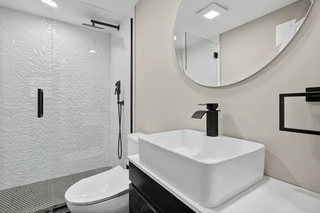 a bathroom with a sink a toilet and shower