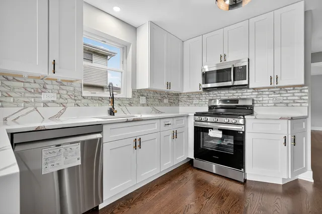 a kitchen with stainless steel appliances granite countertop a sink stove and microwave