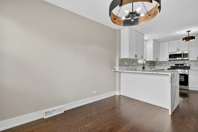 a kitchen with a white cabinets and chandelier