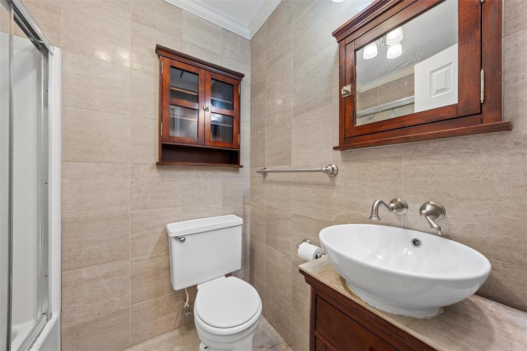 2131 Mountainview Drive Waco, TX 76710 - Photo 13 of 27 Bathroom featuring tile walls, ornamental molding, vanity, and a shower stall