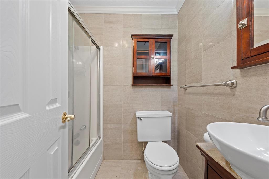 2131 Mountainview Drive Waco, TX 76710 - Photo 19 of 27 Full bath featuring tile walls, shower / bath combination with glass door, crown molding, and vanity