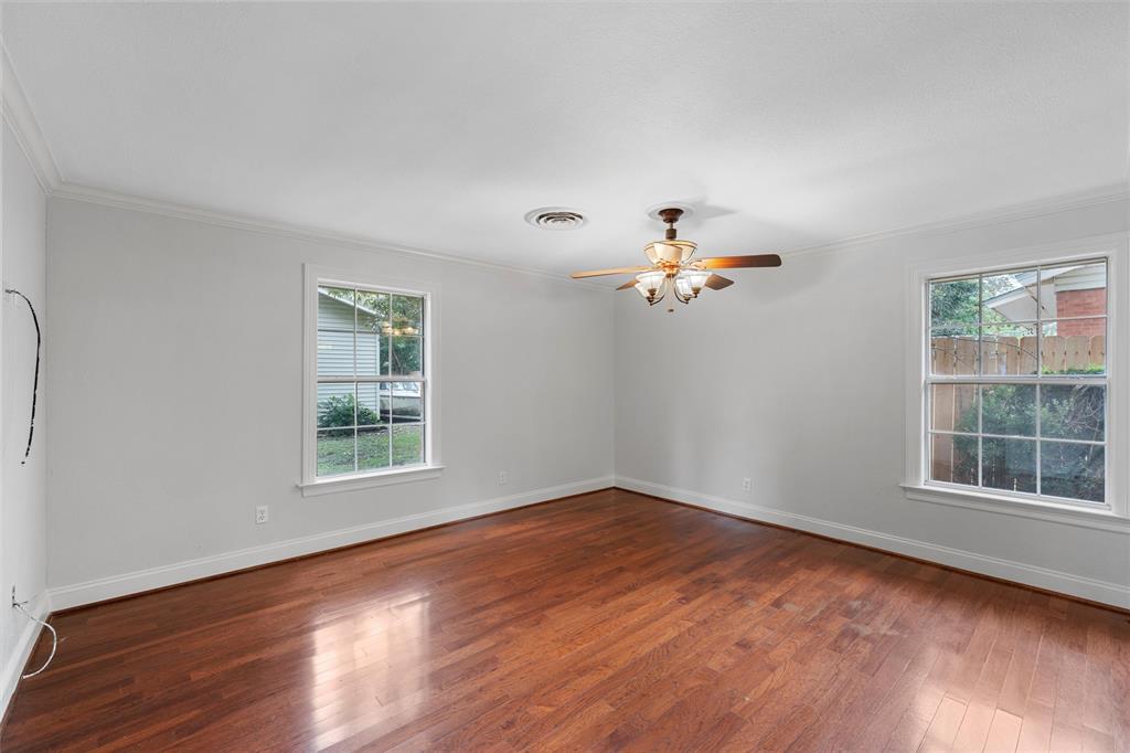 2131 Mountainview Drive Waco, TX 76710 - Photo 20 of 27 Spare room featuring dark wood-type flooring, plenty of natural light, crown molding, and ceiling fan