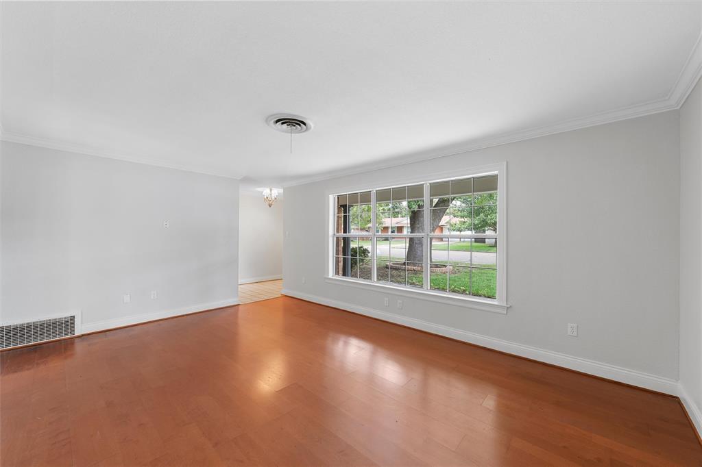 2131 Mountainview Drive Waco, TX 76710 - Photo 4 of 27 Unfurnished room with ornamental molding, wood finished floors, and a chandelier