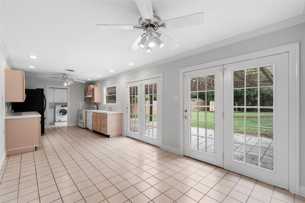 2131 Mountainview Drive Waco, TX 76710 - Photo 6 of 27 Kitchen featuring crown molding, light brown cabinetry, white range with electric cooktop, light tile patterned flooring, and washer / clothes dryer