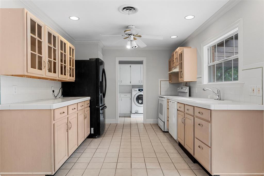 2131 Mountainview Drive Waco, TX 76710 - Photo 7 of 27 Kitchen featuring glass insert cabinets, tasteful backsplash, tile countertops, light brown cabinets, and crown molding